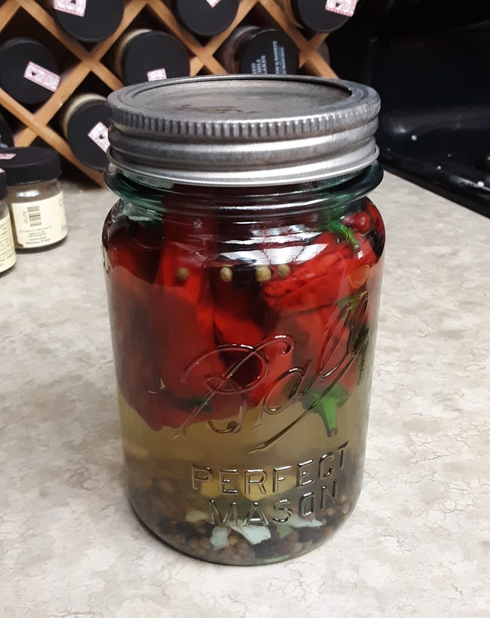 a small jar of pickled red pepporchinis