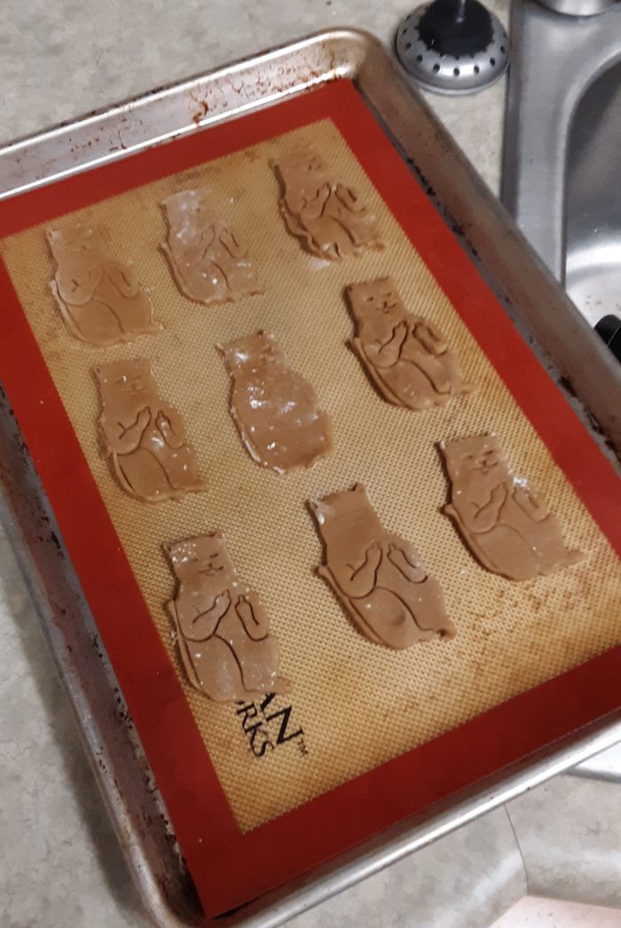 baking sheet with nine unbaked cat-shaped cookies