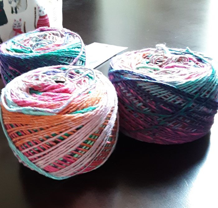 three balls of multi-colored Noro yarn