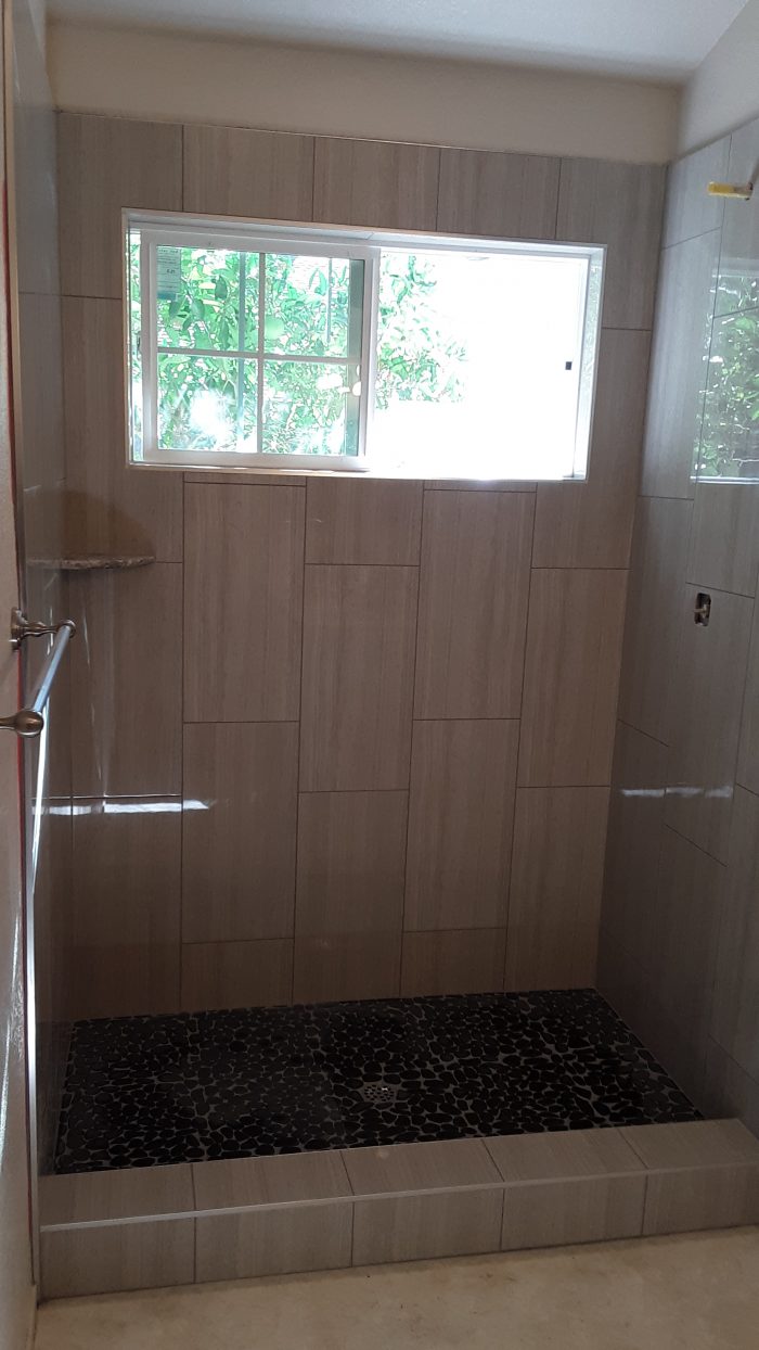 my newly remodeled shower. grey tiles with black "pebble" floor