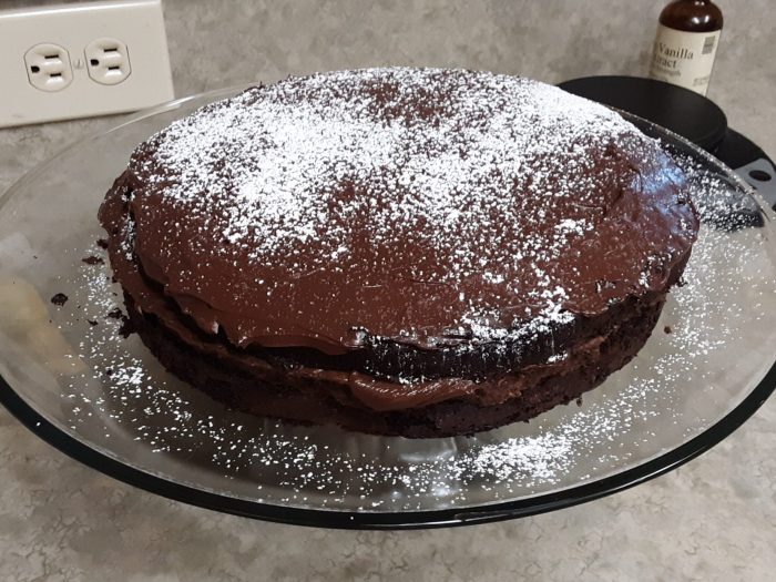 a chocolate cake on a glass cake stand