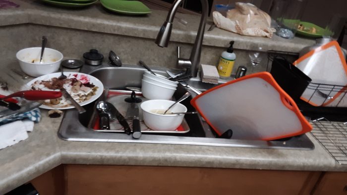 kitchen sink piled high with dishes