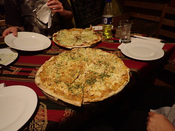 a table with pizzas and plates