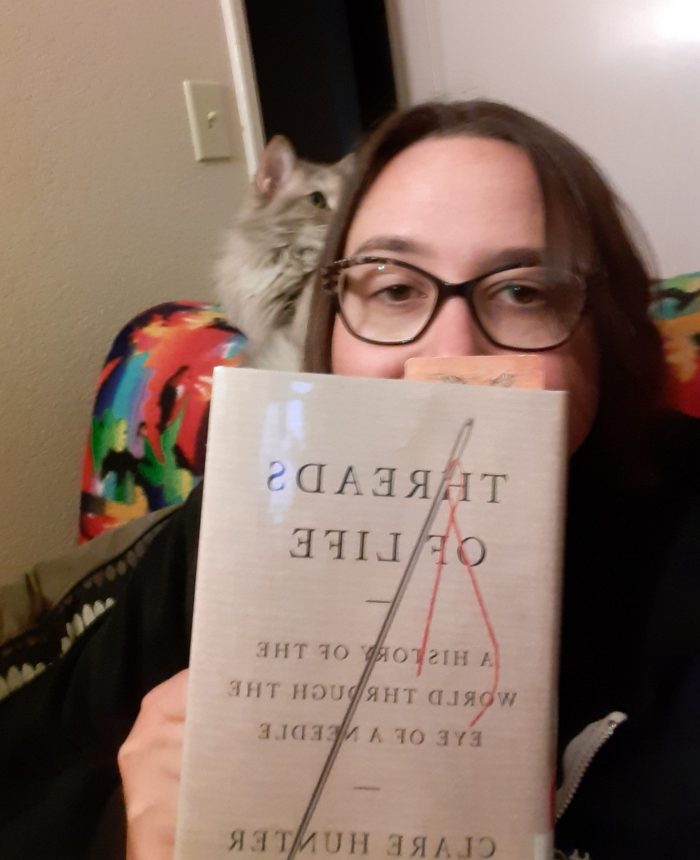 me holding the book "Threads of Life" in front of my face, Viola is in the background