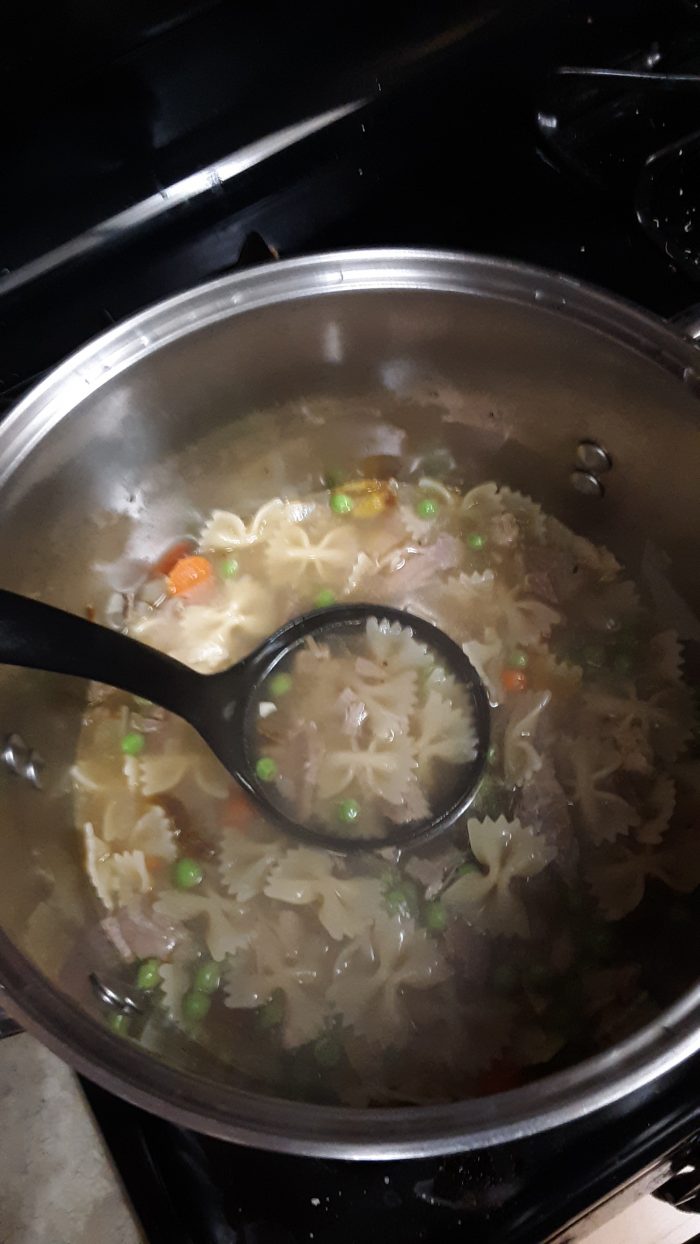 a pot full of turkey noodle soup