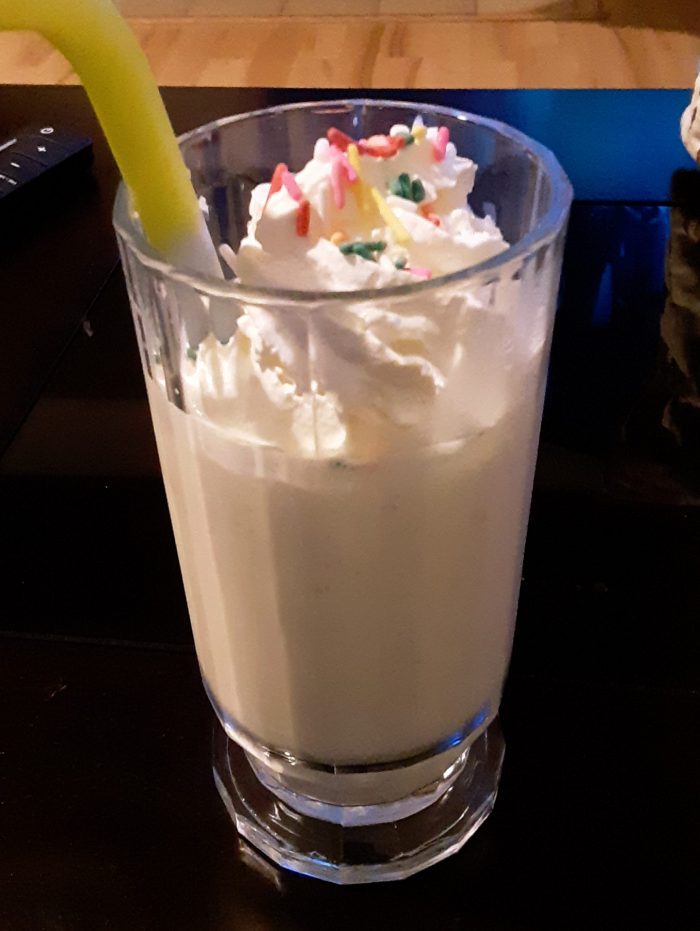 homemade milkshake with whipped cream and rainbow sprinkles