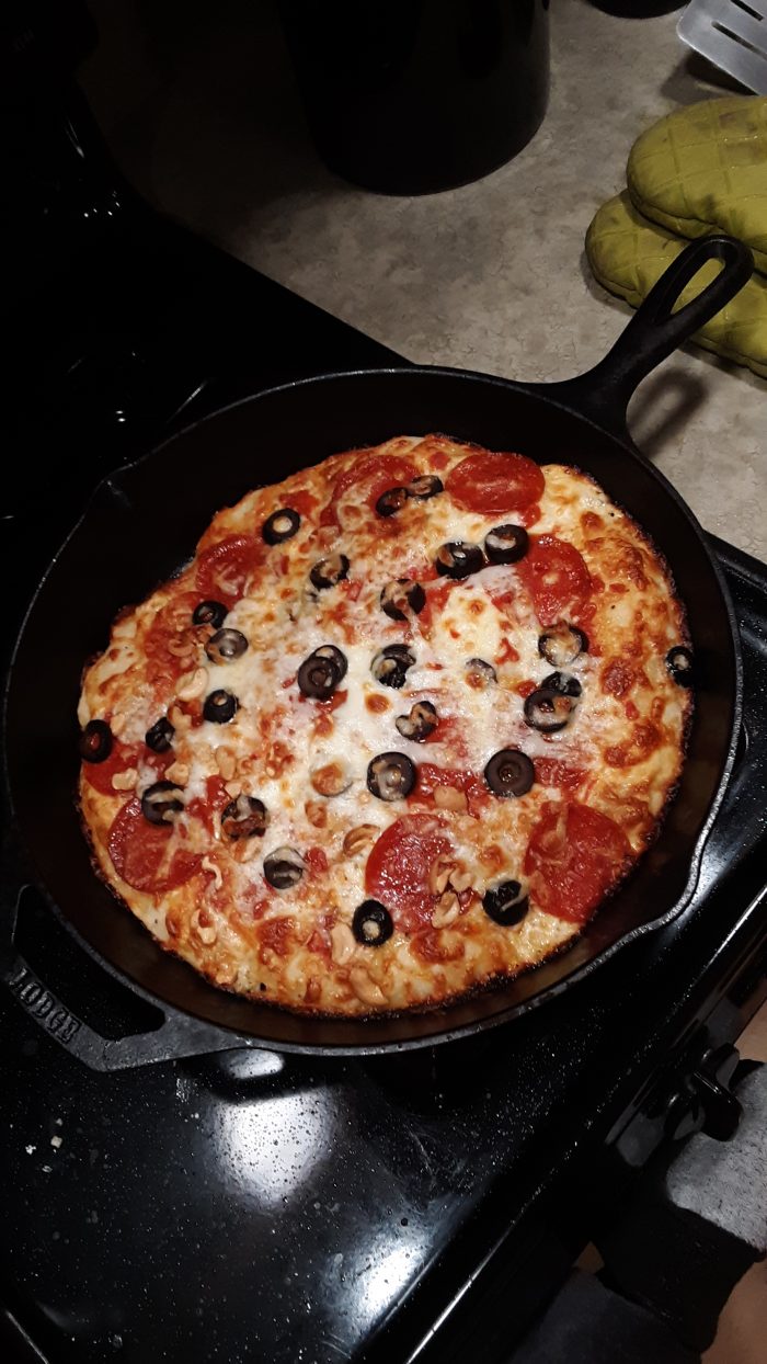 pepperoni and olive pizza cooked in a cast-iron skillet