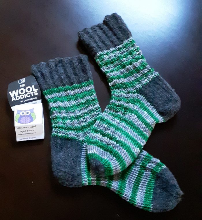 green-and-silve striped socks with grey cuffs, heels, and toes