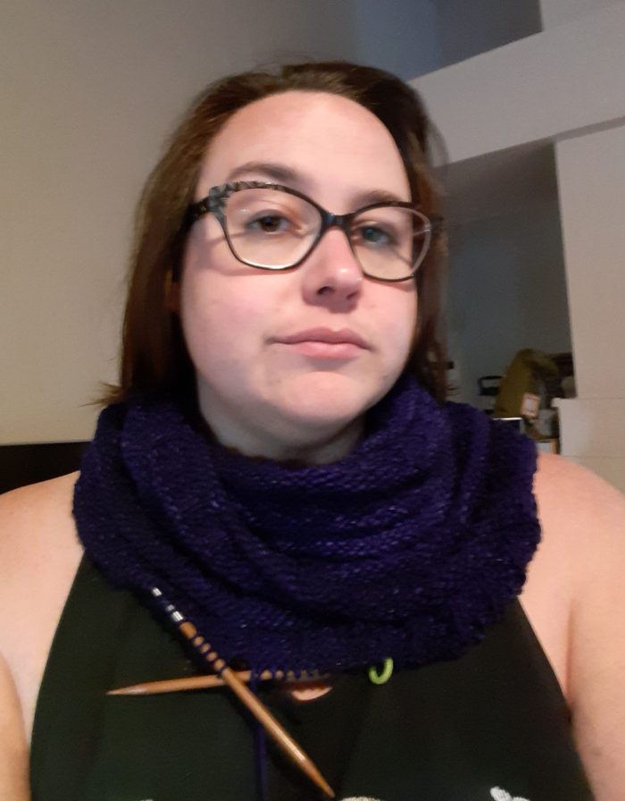 me facing the camera, wearing a cowl knit in purple yarn