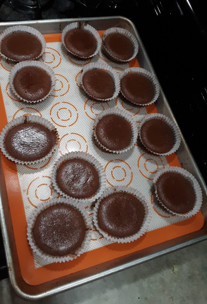 a pan full of chocolate muffins that did not overflow their paper cups
