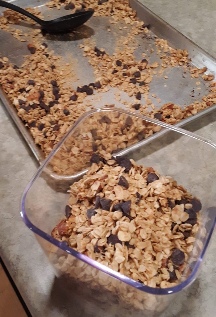 a plastic container of granola next to a sheet pan of the sam