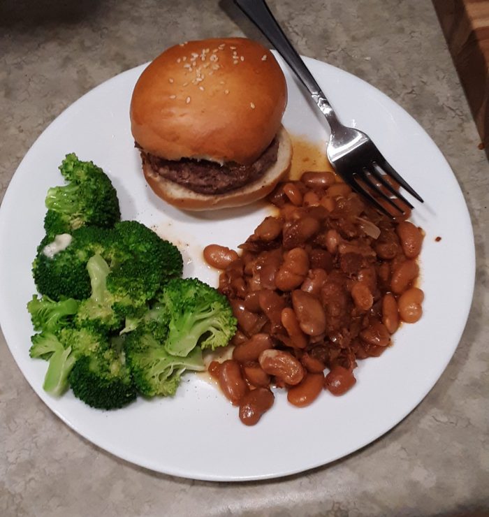 plate with a cheeseburger, baked beans, and broccoli