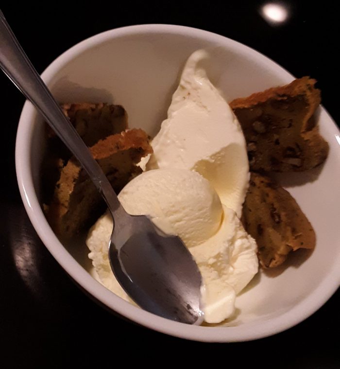 a bowl of ice cream with thin slices of undercooked zucchini bread