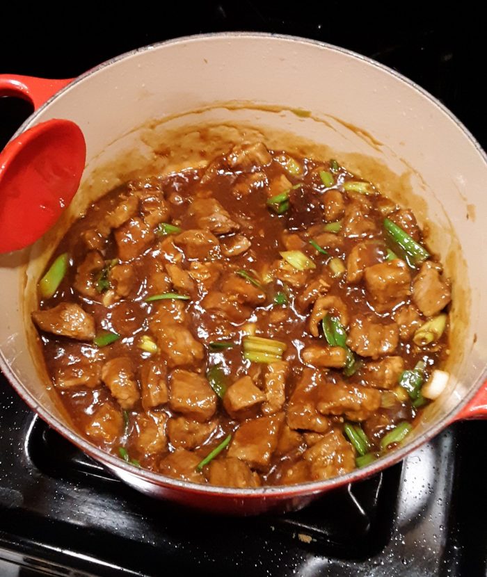a pot of mongolian beef sitting on the stove