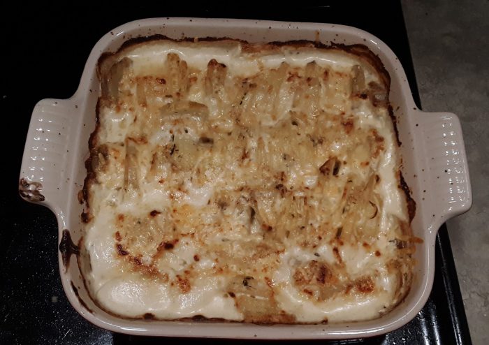 a nine-inch square casserole dish filled with potatoes au gratin