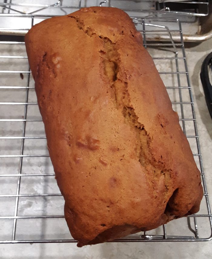 a loaf of banana pumpkin bread cooling on a wire rack