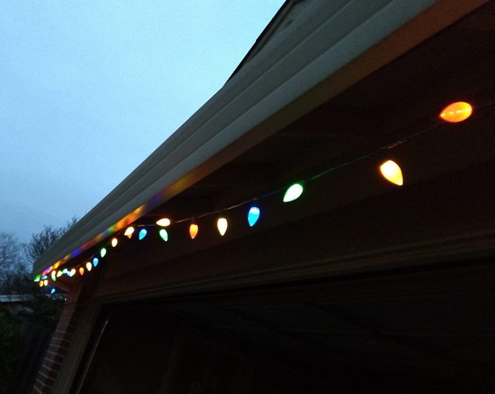 large colorful christmas lights hanging in front of the garage