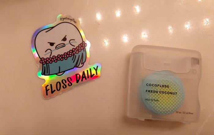 a package of cocofloss and a sticker that says "floss daily"