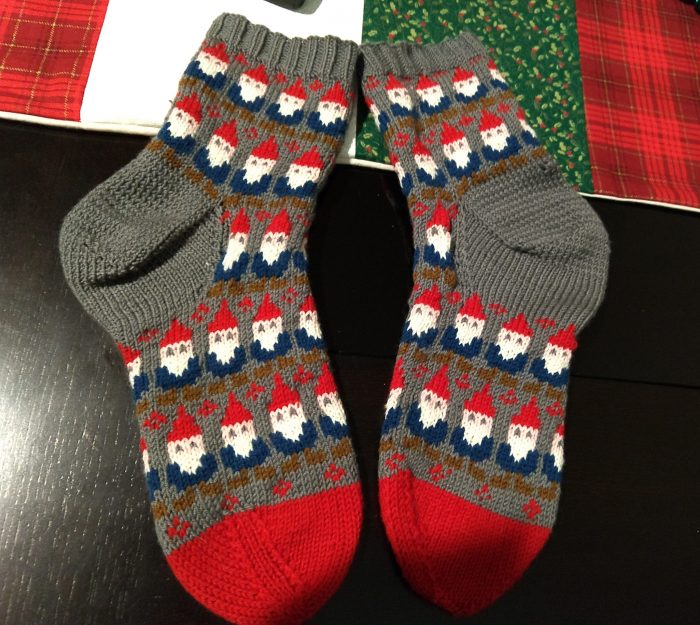grey socks with a red toe, there is a repeating pattern of gnomes wearing red hads, blue shrits and brown boots