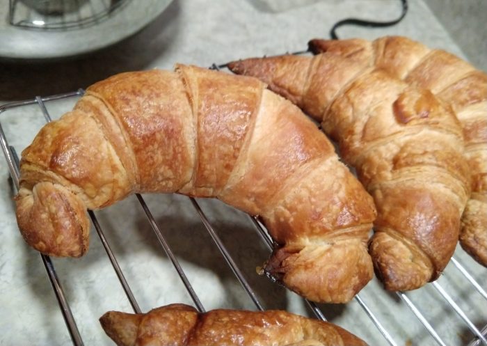 a close-up of croissants cooling on a wire rack