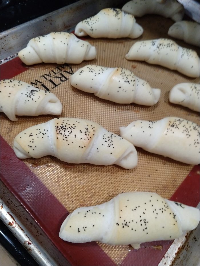 a sheet pan of crescent rolls topped in poppy seed