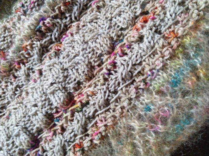 a close up of the knitted wrap showing cables