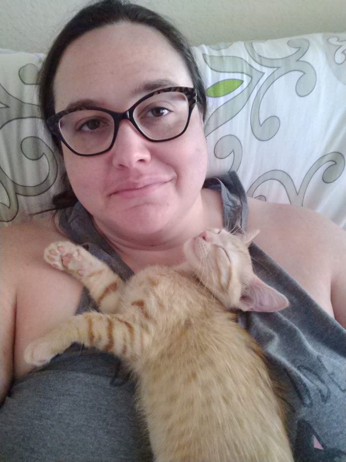 Fritz the orange kitten napping on my chest, me looking at the camera