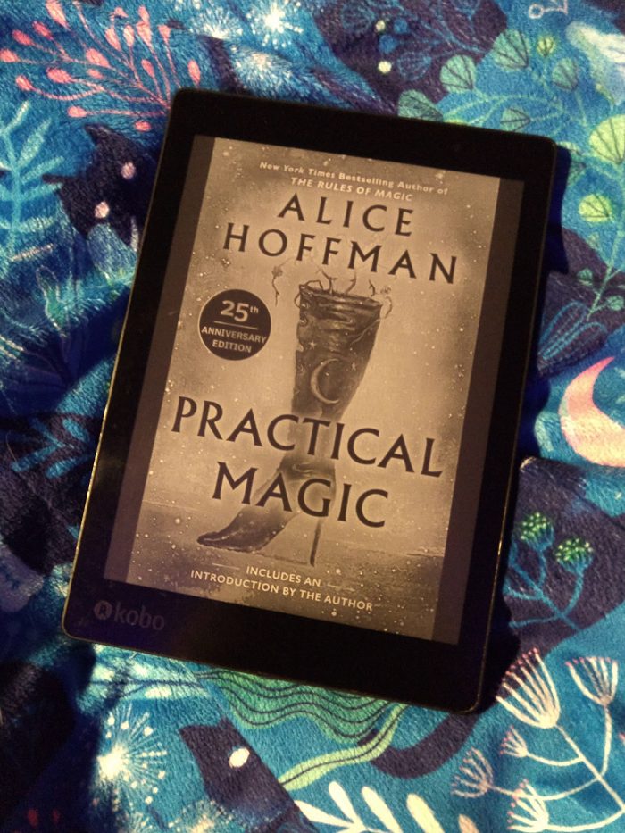 cover of "Practical Magic" shown on kobo ereader, on top of a colorful blue blanket