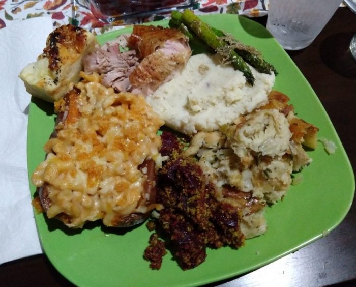 a plate full of thanksgiving foods including turkey and other classics