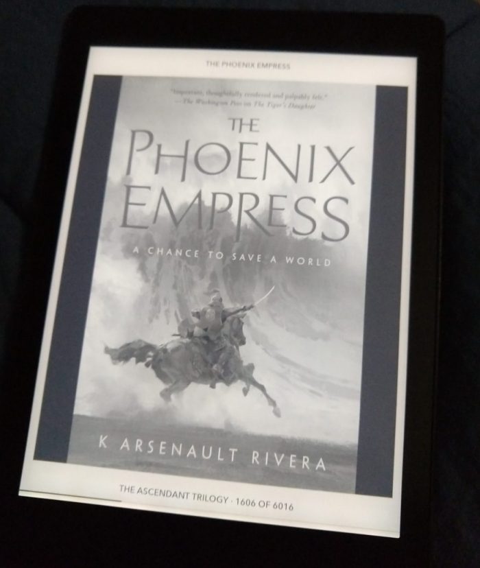 cover of the book The Phoenix Empress shown in greyscale on kobo ereader. Features an armored person with their sword drawn, riding a horse