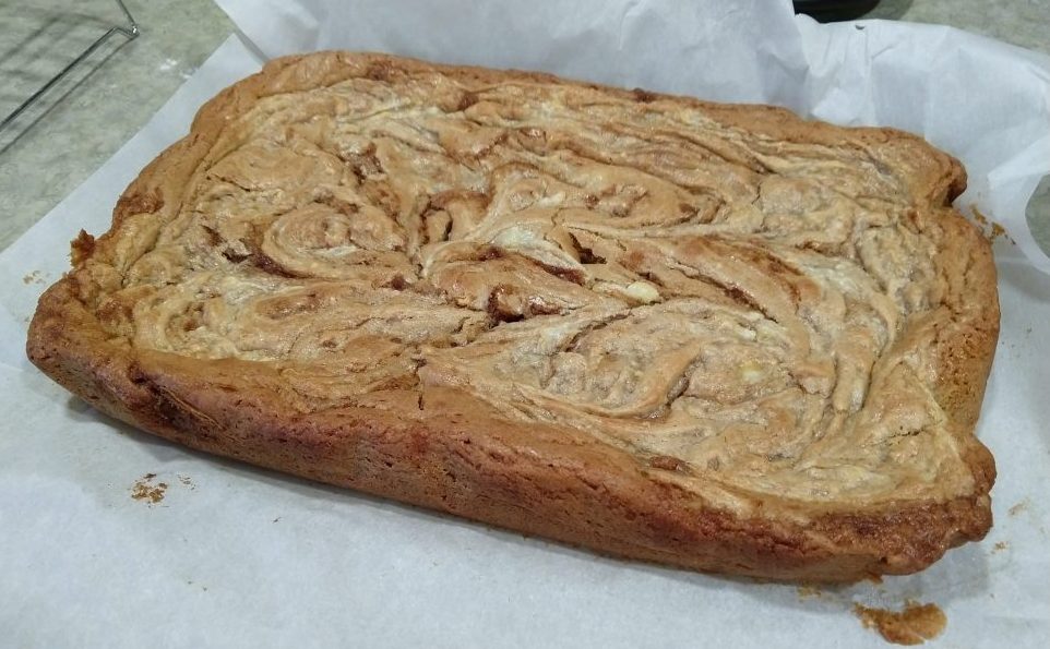 a blondie (straight from the pan and not yet sliced). IT's light brown with swirls of cinnamon sugar and of cream cheese icing.