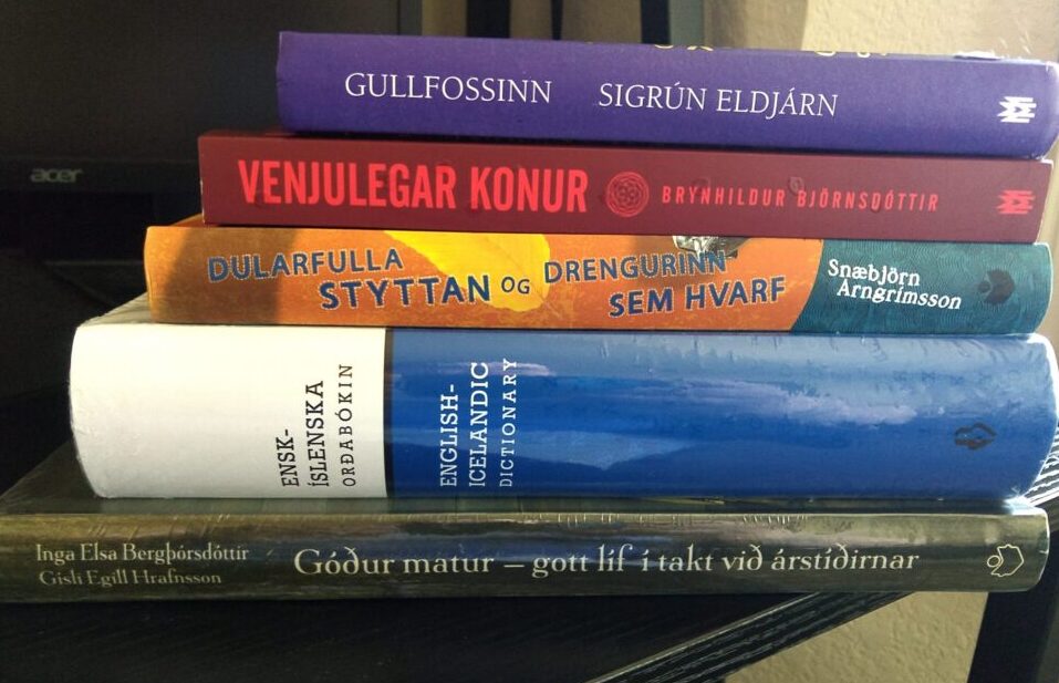 a stack of books including a cookbook in Icelandic, an English-Icelandic dictionary, and three novels