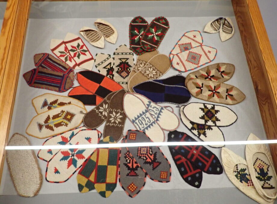 a glass case displaying about 20 pairs of colorful shoe inserts. The patterns feature traditional icelandic motifs.