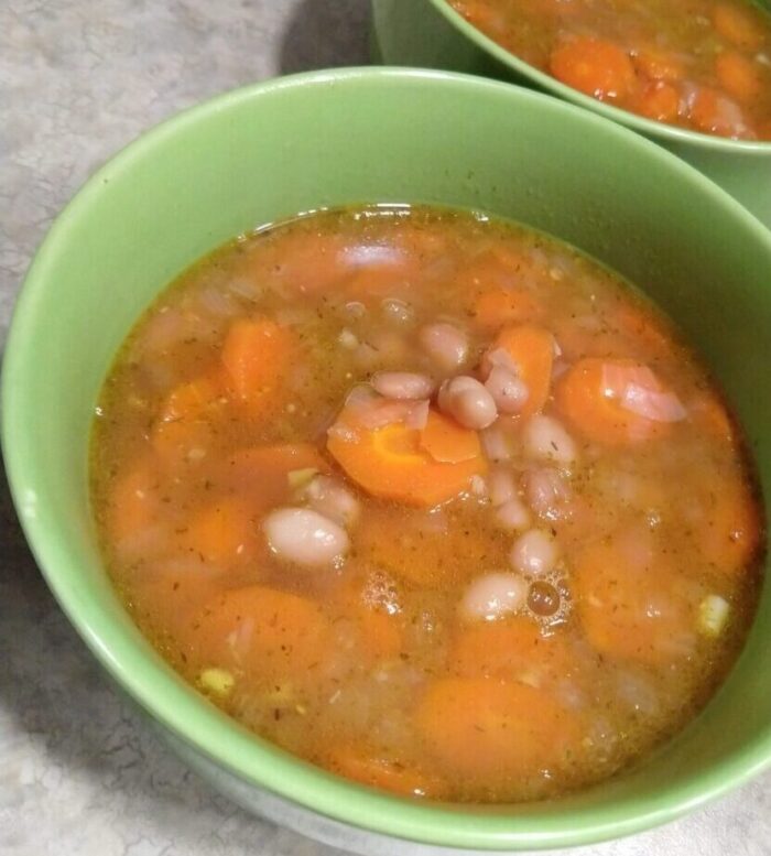 two bowls of brothy carrot bean soup with miso