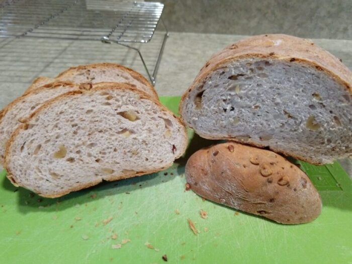 a cross section of a loaf of walnut-onion bread, revealing chunks of walnut and bits of onion inside