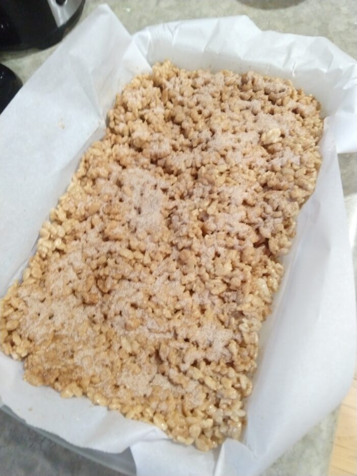 rice krispie treats filled with cinnamon bits and topped with cinnamon and sugar