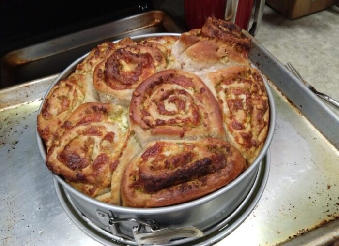 a spring form pan of walnut and pesto rolls, which are bursting up out of the pan