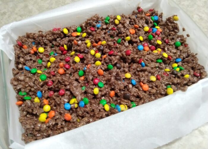 A pan of chocolate rice krispies treats studded with mini M&Ms