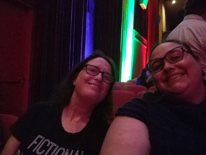 Abby and I in a theater, smiling at the camera. It's not a great photo but we're happy.