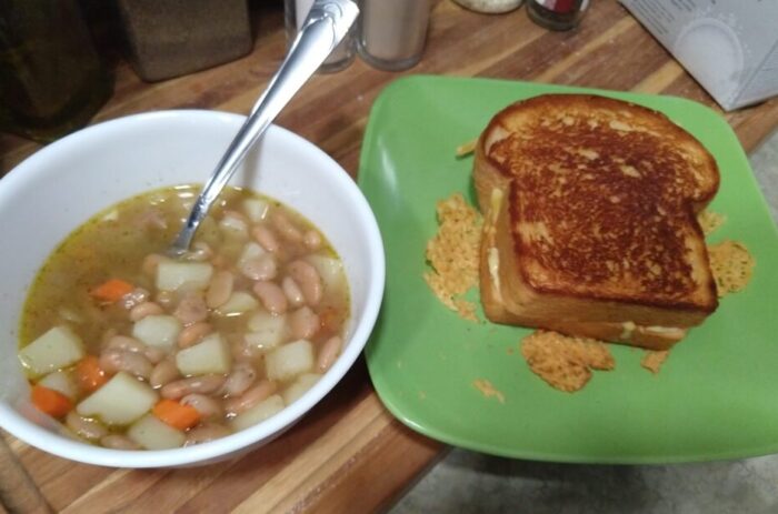 a bowl of bean, potato, and carrot soup and a grilled cheese