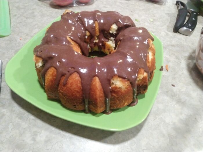 marble pound cake baked in a bundt pan, drizzled with chocolate icing