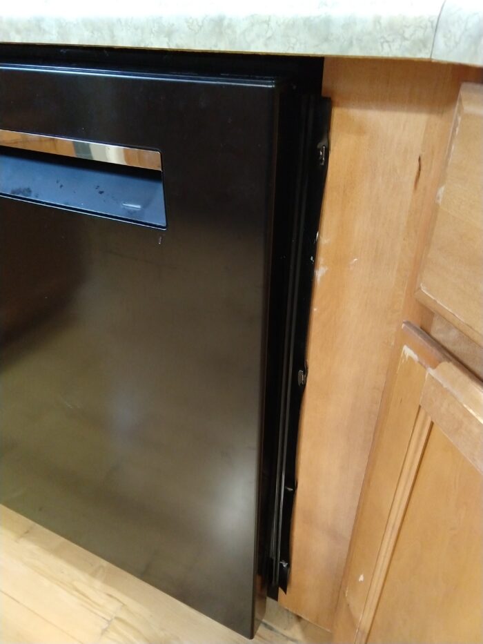 dishwasher flaps stapled with big, staple-gun staples to the cabinetry
