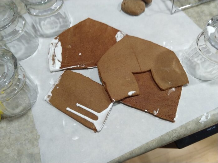 failed attempt at a gingerbread house. The house pieces have icing on their edges and are in a heap on the counter.