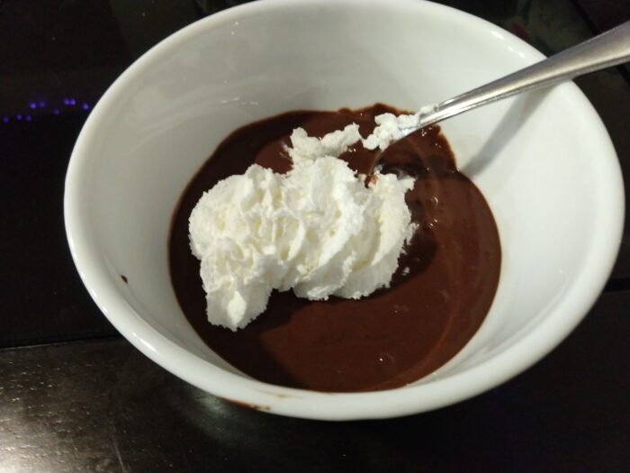 a bowl of chocolate pudding topped with whipped cream