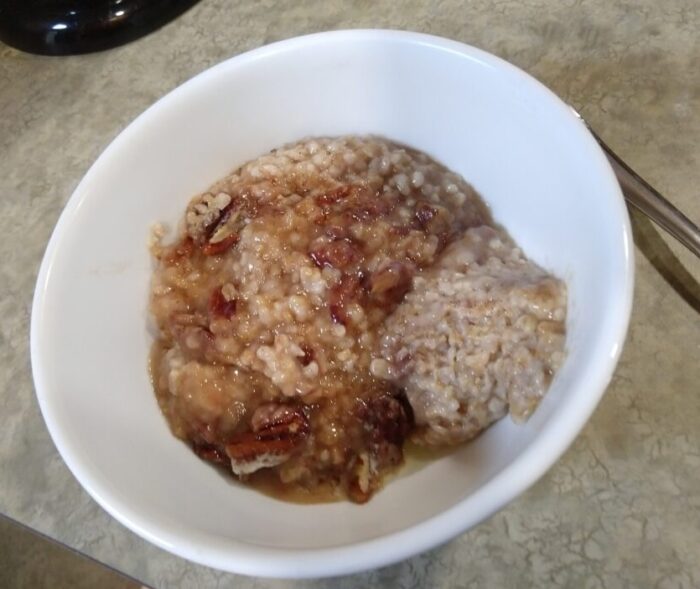 a bowl of baked steel-cut oats topped with sugar and pecans