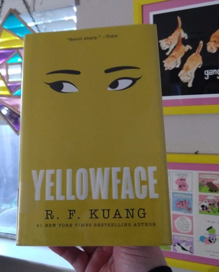 Hardback book: Yellowface. The cover is all yellow and minimalist with just a pair of eyes and the title