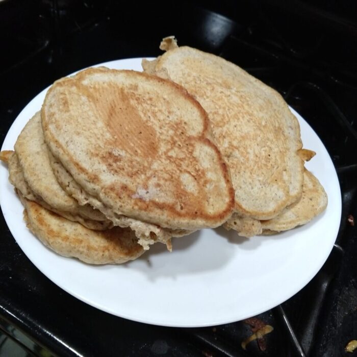 A small pile of oval pancakes stacked on a plate