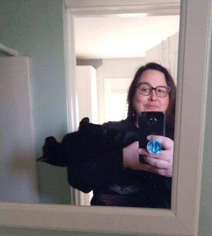 me holding Riff Raff the cat like a baby. Photo taken in the mirror.