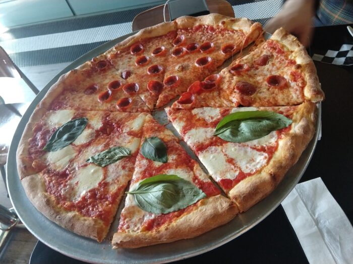 A big, thin-crust pizza. Half pepperoni and half cheese with basil