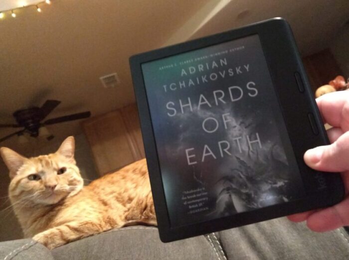 cover for Shards of Earth shown on kobo ereader. Fritz the cat is in the background looking unimpressed